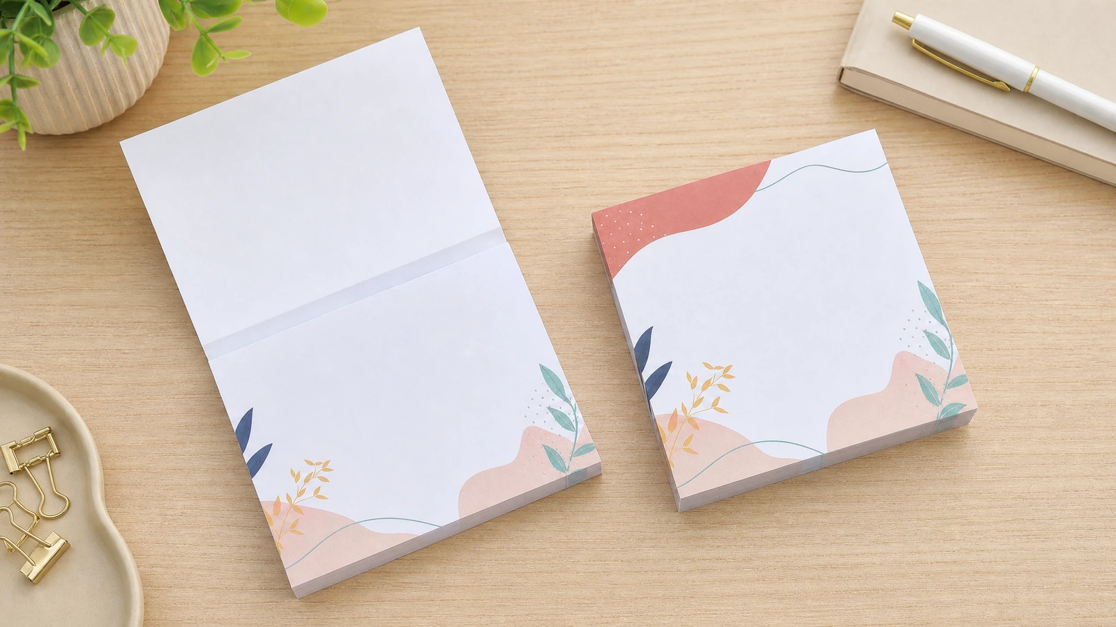 めくれた一枚と、並べて置かれた同じ柄の閉じたパッドがある花柄メモパッド