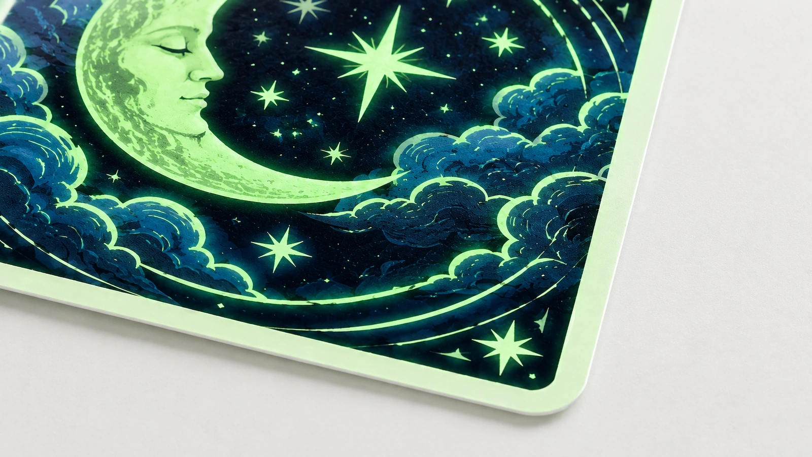 月と星のステッカーの細部 角の丸い正方形ステッカーに描かれた、緑の三日月、星、雲のクローズアップ