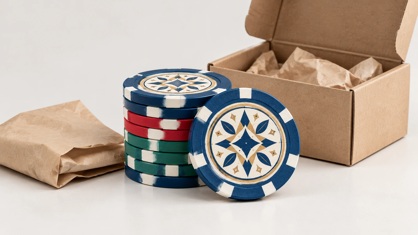 ポーカーチップと梱包材 開いたクラフト箱と紙で包まれた品物の横にある、多色のポーカーチップのスタック